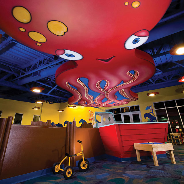 View of the large octopus mural on the ceiling inside the Kids World childcare center at ClubSport Aliso Viejo