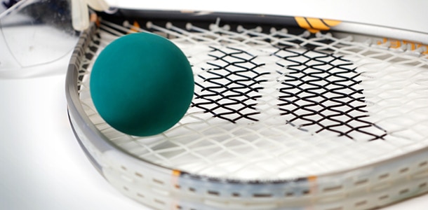 Racquetball racquet and ball laying on a court