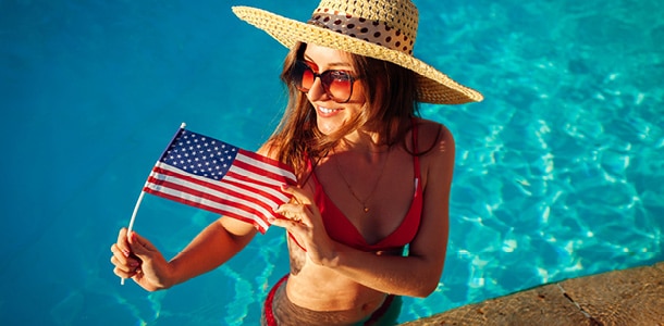 A woman in the pool holding a small American flag