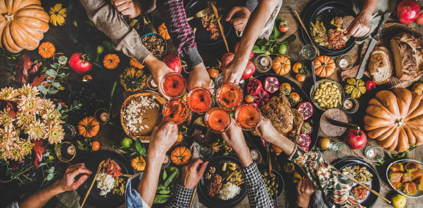 A group of friends doing a cheers during a Friendsgiving celebration