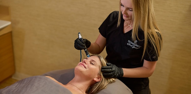 A woman getting a hydrafacial treatment during the holiday hydrafacial promotion