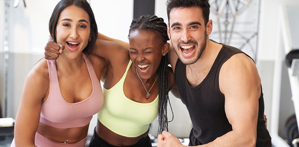 Three friends flexing their muscles for the Fit Feb Competition