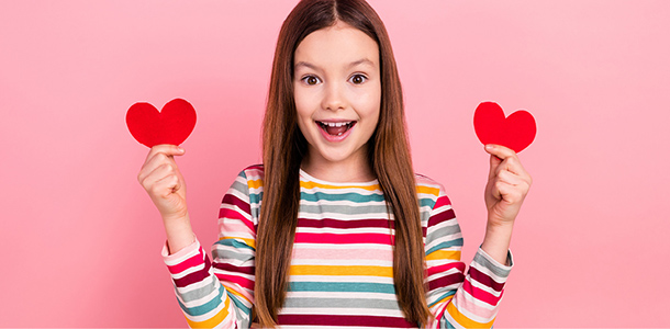 A child holding cut out Valentine's Day hearts for Parents' Escape