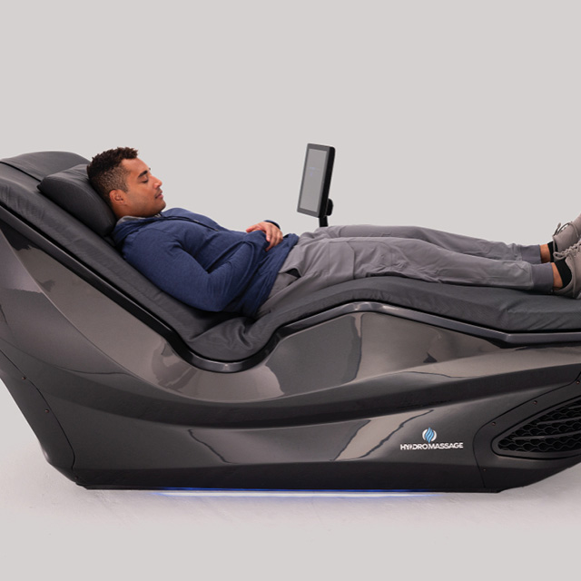 A man relaxing in a HydroMassage recovery bed as part of his wellness routine