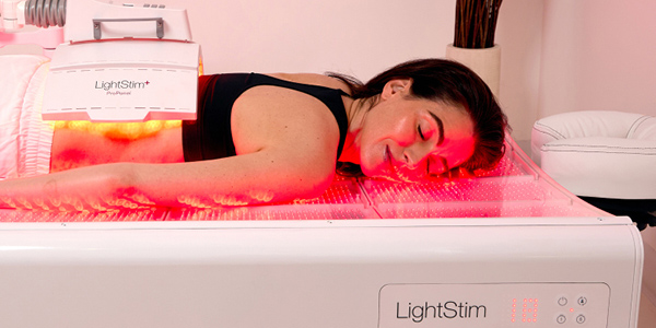 A woman enjoying red light therapy at ClubSport Aliso Viejo