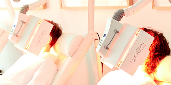 A woman using the LightStim ProPanel to treat acne and wrinkles