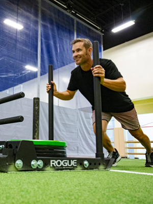 Man pushing a weighted sled in The Edge Performance Training Space