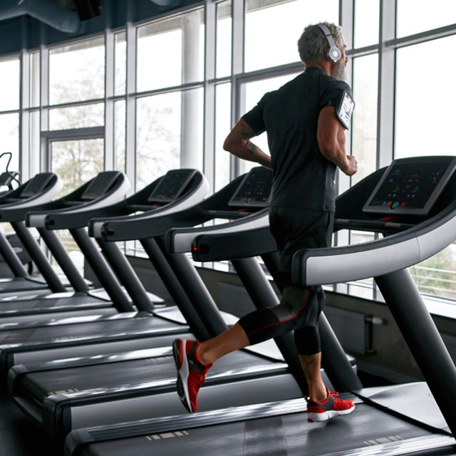 A man running on a treadmill on the premier fitness floor with cardio equipment
